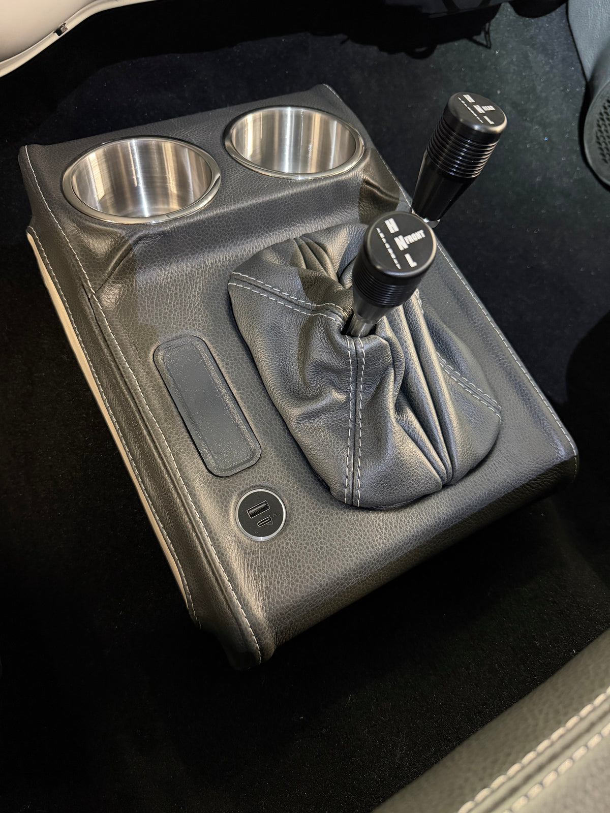 Leather wrapped shifter console with stainless cup holders and USB charger